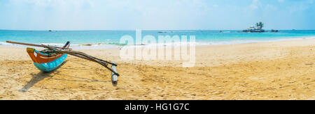 Das weite Panorama der gemütlichen Sandstrand mit einem Katamaran-Boot und Seenigama Muhudu Viharaya buddhistischen Tempel befindet sich auf der kleinen Insel im Ozean, Hi Stockfoto