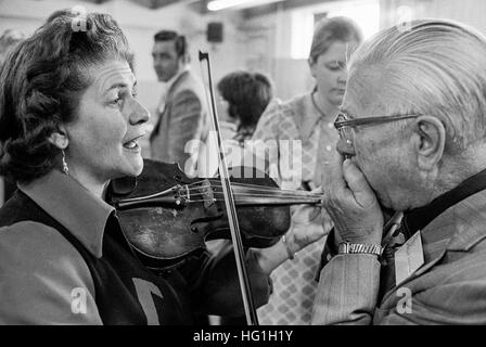 Frau Geiger und einem älteren männlichen Mundharmonika-Spieler Proben hinter den Kulissen bei einem Folk-Musik-Festival und Wettbewerb in Vermont. Stockfoto