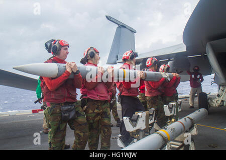 PHILIPPINENSEE (22. November 2013) Aviation Ordnancemen bereiten eine AIM-120-Rakete auf eine F/A-18E Super Hornet aus der königlichen Streitkolben des Strike Fighter Squadron (VFA) 27 auf dem Flugdeck des Flugzeugträgers USS George Washington (CVN-73) geladen. George Washington und seine eingeschifften Geschwader Carrier Air Wing (CVW) 5, bieten eine kampfbereit Kraft, die schützt und verteidigt das kollektive maritimen Interesse der USA und ihrer Verbündeten und Partner in der Indo-Asien-Pazifik-Region. (Foto: U.S. Navy Mass Communication Specialist 3. Klasse Ricardo R. Guzman/freigegeben) 131122-N-BX824-054 beitreten die Conv Stockfoto