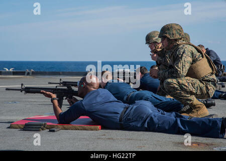 Matrosen Feuer m-16 Sturmgewehre mit der Beaufsichtigung der Marines, 2. Bataillon, 9. Marines, während ein Kleinwaffen Waffen Requalifizierung Shooting auf dem Flugdeck der amphibischen Dock Landungsschiff USS Germantown (LSD 42) zugeordnet. Germantown ist Teil von der Peleliu amphibische bereit Gruppe (#PELARG14), unter dem Kommando von Captain Heidi Agle und führt gemeinsame Streitkräfte Übungen in den USA 7. Flotte Aufgabengebiet. (Foto: U.S. Navy Masse Kommunikation Spezialist Seemann Patrick Dionne/freigegeben) USS Germantown Operationen 141104-N-XM324-112 Stockfoto