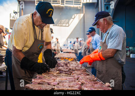 Köche aus dem Tal Freiwilligen Kochen Steaks für Segler an Bord der Flugzeugträger der Nimitz-Klasse USS George Washington (CVN-73) stationiert. Die Köche aus dem Tal ist eine heterogene Gruppe von Geschäftsleuten und Frauen, die seit 2001 ca. 53 Tonnen von Harris Ranch, 12oz New York Steaks nach mehr als 140.000 Matrosen und Marinesoldaten auf der ganzen Welt geliefert haben. (Foto: U.S. Navy Masse Kommunikation Spezialist Seemann Loni Mae Lopez/freigegeben) USS George Washington Operationen 141106-N-ZK360-151 Stockfoto