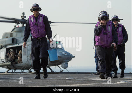 Das Tankstellen-Team an Bord der Dock-Landungsschiff USS Comstock (LSD 45) löscht aus dem Flugdeck während ein UH-1Y Huey Hubschrauber zugewiesen, Marine Medium Tiltrotor Squadron (VMM) 163 (Reinforced) bereitet, zu starten. Comstock ist Teil der Makin Island amphibische bereit-Gruppe und mit der 11. Marine Expeditionary Unit wird eingesetzt zur Unterstützung der maritimen und Theater Sicherheitskooperation in den USA 5. Flotte Aufgabengebiet. (Foto: U.S. Navy Mass Communication Specialist 3. Klasse Lenny LaCrosse/freigegeben) USS Comstock Operationen 141216-N-CU914-210 Stockfoto