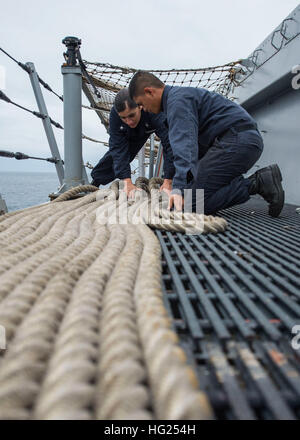 150305-N-EI510-022 OKINAWA, Japan (5. März 2015) Boatswain Mate 3. Klasse Maribel Salazar, links, Seaman Kimber Albastro Griff Linie vorwärts bereitgestellten amphibious Transport Dock Schiff USS Green Bay (LPD-20).  Green Bay ist der Austausch der stillgelegten Austin-Klasse amphibischen Dock Transportschiff USS Denver (LPD-9), zuvor vorwärts nach Sasebo, bereitgestellt und amphibische Präsenz in den USA verbessern wird 7. Flotte als Bestandteil der US-Marine Langstrecken Plan, am meisten fortgeschrittene und in der Lage, Einheiten an der Asien-Pazifik-Region zu senden. (Foto: U.S. Navy Mass Communication Specialist 3. Klasse S Stockfoto