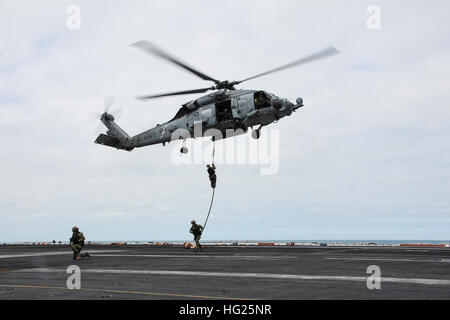 150322-N-ZF498-362 Atlantik (22. März 2015) Explosive Ordnance Entsorgung Matrosen führen eine schnelle Seil Übung aus einer HH - 60 H Sea Hawk Hubschrauber "Drachentötern" der Hubschrauber Anti-Submarine Squadron (HS) 11 mit auf dem Flugdeck der Flugzeugträger der Nimitz-Klasse USS Theodore Roosevelt (CVN-71) während einer Demonstration Airpower 22. März 2015 zugeordnet. Theodore Roosevelt, in Norfolk, Gridley führt Marinebetriebe in den USA 6. Flotte Bereich der Maßnahmen zur Erhöhung der Sicherheit der Vereinigten Staaten in Europa interessiert. (Foto: U.S. Navy Mass Communication Specialist 3. Cl Stockfoto