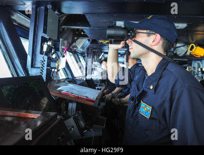 150825-N-PG340-020 arabischen Golf (25. August 2015) – Lt. Cmdr. Will Sauer aus Rochester, N.Y., steht Officer Of The Deck unter Anleitung blicken auf Brücke an Bord des Flugzeugträgers USS Theodore Roosevelt (CVN-71). Theodore Roosevelt wird in den USA 5. Flotte Einsatzgebiet unterstützen Betrieb innewohnende zu beheben, Streik Operationen im Irak und in Syrien, wie verwiesen, maritime Sicherheit und Theater Sicherheitsbemühungen Zusammenarbeit in der Region bereitgestellt. (Foto: U.S. Navy Mass Communication Specialist 3. Klasse Stephane Belcher/freigegeben) USS Theodore Roosevelt Operationen 150825-N-PG340 - Stockfoto