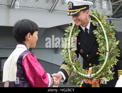 160313-N-BR551-021 BUSAN, Südkorea (13. März 2016) - A Busan, Südkorea Boy präsentiert Captain Greg Huffman, USS John C. Stennis' (CVN-74) Kommandierender Offizier, mit einem Kranz von Blumen während einer Willkommenszeremonie, nachdem das Schiff in den Hafen zieht. Bereitstellung einer bereit Kraft unterstützende Sicherheit und Stabilität in der Indo-Asien-Pazifik, ist Stennis als Teil der großen grünen Flotte auf einer regelmäßig stattfindenden 7. Flotte Bereitstellung tätig. (Foto: U.S. Navy Masse Kommunikation Spezialist Seemann Dakota Rayburn / veröffentlicht) Begrüßung in Busan 160313-N-BR551-021 Stockfoto