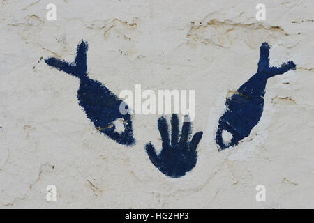 Nahaufnahme Bild von Hand und Fisch Symbol auf traditionelle Berber Hauswand in der sahara Stockfoto