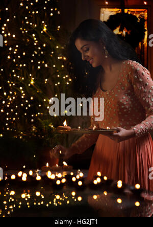 Junge Frau Anordnen von Öllampen an einem Diwali-fest Stockfoto