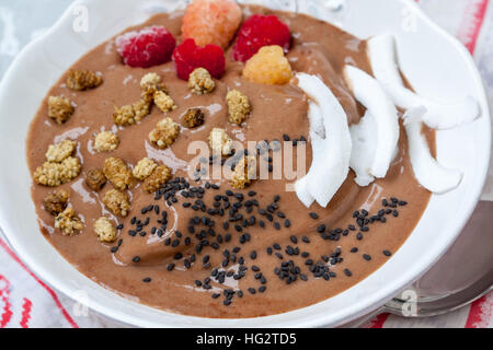 Schokolade Smoothie Schüssel Haferflocken, Sesam und Himbeeren zum Frühstück. Liebe für eine gesunde Rohkost-Konzept. Stockfoto