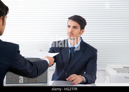 Geschäftsmann Übergabe Dokument zu junge Mann im Büro Stockfoto