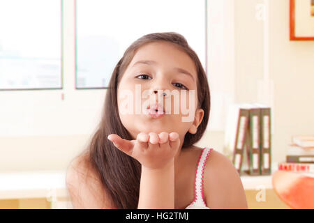 Portrait von lächelnden Mädchen bläst Küsse Stockfoto