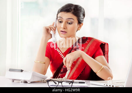 Attraktive indische Rezeptionist sprechen über das Telefon Stockfoto