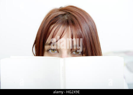 schönes Mädchen liest ein Buch in ihrem Bett, Nahaufnahme für Augen Stockfoto