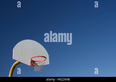 Ein Basketball-Rückwand mit Netz und Reifen haben einen klaren, blauen Himmelshintergrund Stockfoto