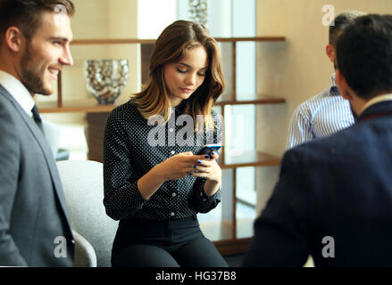 Teamarbeit-Konzept, Brainstorming. Geschäftsmann Mannschaft arbeitet mit neuen Startprojekt in modernen Loft. Frau Smartphone Händchenhalten. Horizontal, Film-Effekt. Stockfoto