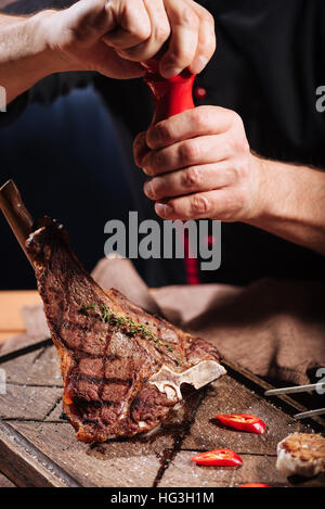 Nahaufnahme von mans Hände Fleisch salzen Stockfoto