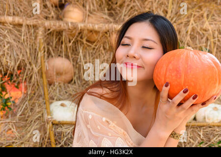 Closeup Portrait glückliche Frau und halten einen große orangenen Kürbis in der hand Stockfoto