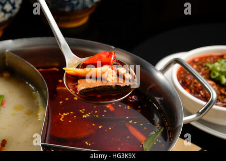 Szechuan Hotpot - würzige chinesische Eintopf mit Rindfleisch, Tofu, Garnelen, Pilze, grüne Blätter und Nudeln. Stockfoto