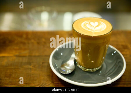 Tasse Kaffee Latte auf Tisch auf hellem Hintergrund Stockfoto