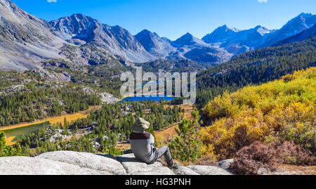 Wanderer am Aussichtspunkt neben der Mono Pass Trail entspannende sieht kleine Seen-Tal im Rock Creek Canyon in der östlichen Sierra Stockfoto