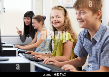 Weibliche Grundschule Schüler im Informatikunterricht mit Lehrer Stockfoto