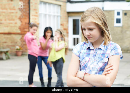 Unglückliche Mädchen wird durch Schulfreunde über geplaudert Stockfoto