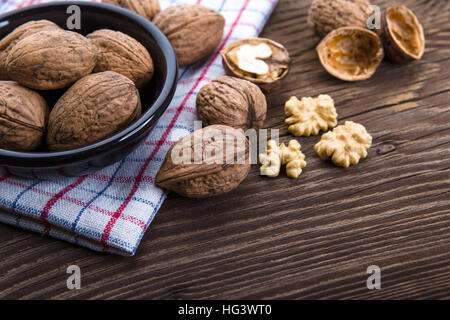 Walnuss-Kerne und ganze Walnüsse auf alten Holztisch Stockfoto