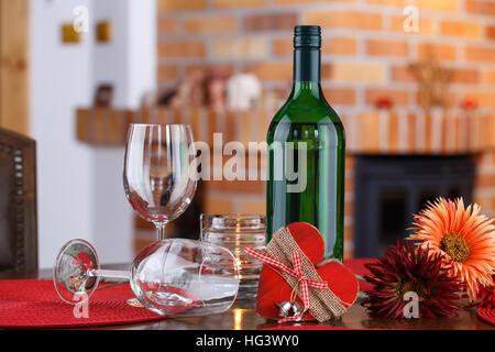 Stillleben mit Flaschen Wein, Gläser, Blumen und Herz-Symbol auf dem Hintergrund einer gemauerten Kamin Stockfoto