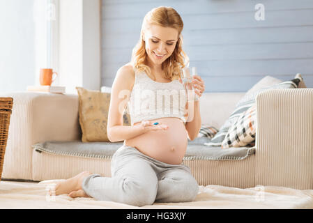 Schwangere Frau Pillen im Schlafzimmer Stockfoto