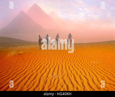 Die Pyramiden und vier Kamel Fahrer im Morgengrauen auf dem Plateau von Gizeh, Kairo, Ägypten Stockfoto