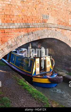 Kanalboot auf dem Kanal vorbei unter eine Brücke an einem Dezembermorgen. Napton auf dem Hügel, Warwickshire, England Stockfoto