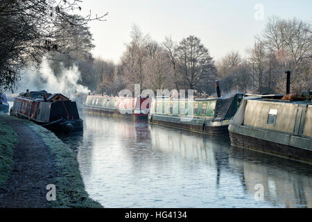 Kanalboot mit Rauchen Schornstein am Oxford-Kanal auf einem frostigen Dezembermorgen. Cropredy, Oxfordshire, England Stockfoto