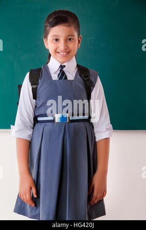 Portrait von Mädchen mit Schulranzen im Klassenzimmer Stockfoto