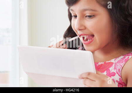 Süße Mädchen setzen auf Lippenstift in Spiegel Stockfoto