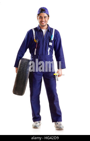 Portrait von Automechaniker mit Reserverad und Handwerkzeuge Stockfoto
