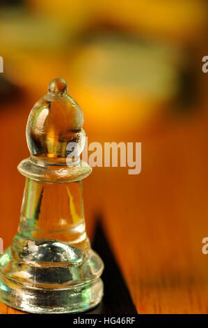 Hautnah - Glas Schachfigur. Bischof im Vordergrund und Chips im Hintergrund Stockfoto