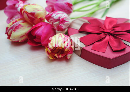 Strauß Tulpen und Geschenk-Box mit roter Schleife Stockfoto