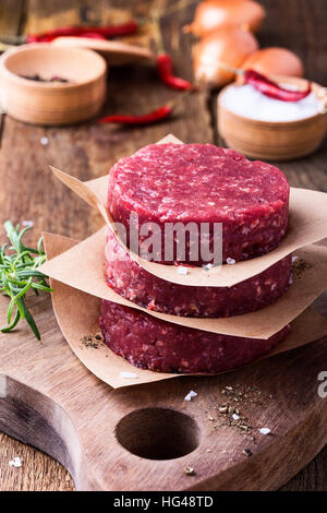 Bio rohes Hackfleisch, runde Fladen für die Herstellung von hausgemachten Burger auf Holzbrett Stockfoto