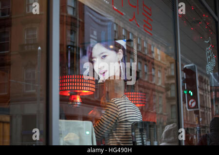 Koreanisch, Restaurant, Café, noodle bar, tv, video, Fenster, Mann, beobachten, Essen, dim Sum, Kimchee, Straße Stockfoto