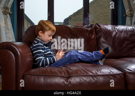 Kind mit Technologie. 5 Jahre alten Jungen mit einem Tablet-PC oder iPad Stockfoto