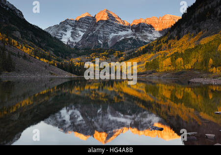 Wunderschönen Sonnenaufgang berührt Maroon Bells Peak bei Maroon See, Aspen, Colorado. Herbstfarben von Aspen und Reflexion von Maroon Bells Stockfoto