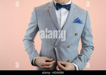 Mann im grauen Anzug, karierten Textur, blaue Fliege und Einstecktuch, weißen Hintergrund hautnah Stockfoto
