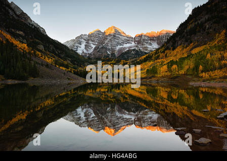 Wunderschönen Sonnenaufgang berührt Maroon Bells Peak bei Maroon See, Aspen, Colorado. Herbstfarben von Aspen und Reflexion von Maroon Bells Stockfoto