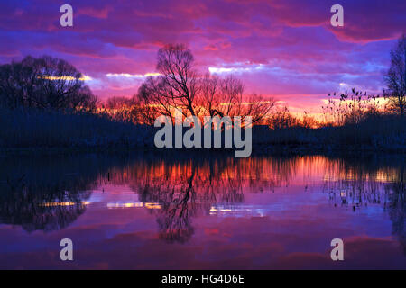 hellen Sonnenuntergang auf einem wilden See in lila Tönen Stockfoto