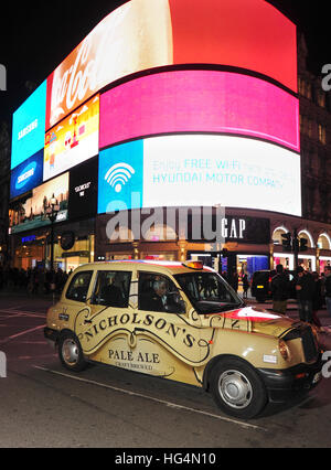 London Taxi in Piccadilly Circus bei Nacht Stockfoto