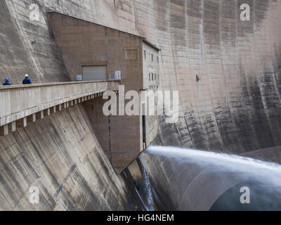 Freisetzung von Wasser und zwei Arbeiter auf beeindruckende Katse Dam Wasserkraftwerk in Lesotho, Afrika Stockfoto