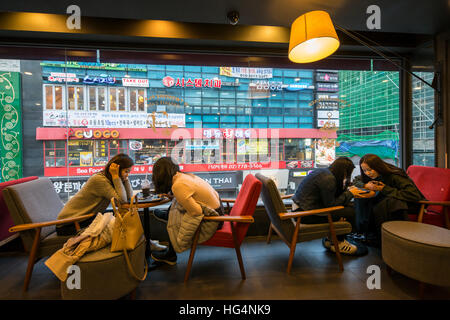 4 junge Frauen in einem Café, Seoul, Korea Stockfoto