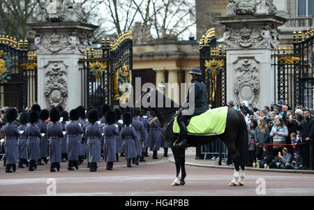 Ein berittener Polizisten blickt auf als Band der Haushalt Abteilung spielt bei der Wachablösung am Buckingham Palace in London. Stockfoto