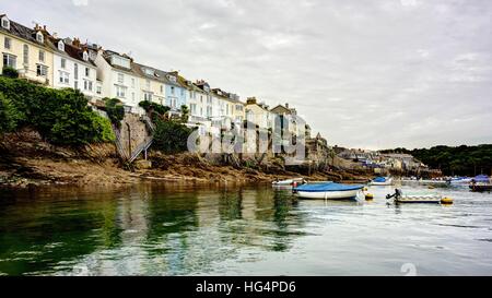 Ein Panorama-Landschaft festgemachten Boote in Fowey-Mündung nach oben aus dem ruhigen Hafen-Wasser zu den Häusern entlang des Ufers. Stockfoto