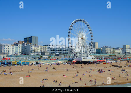 Das Riesenrad auf dem Madeira Drive mit vielen Leuten, die sich am Strand vor dem Pier von Brighton, East Sussex, England, Großbritannien, entspannen, wurde im Mai 2016 entfernt. Stockfoto
